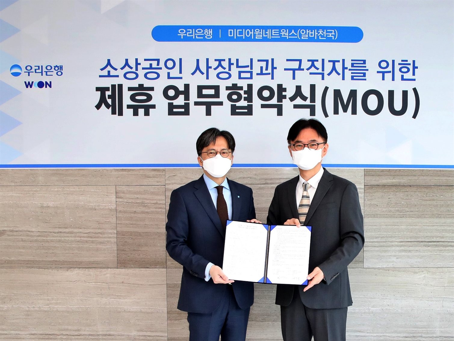 황원철(왼쪽) 우리은행 디지털금융그룹 상무가 공선욱 미디어월네트웍스 대표와 기념촬영을 하고 는 모습. 사진ㅣ우리은행